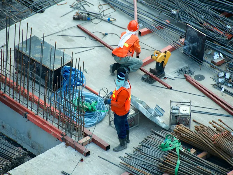 Construction workers in hi-vis vests on a building site, seen from above