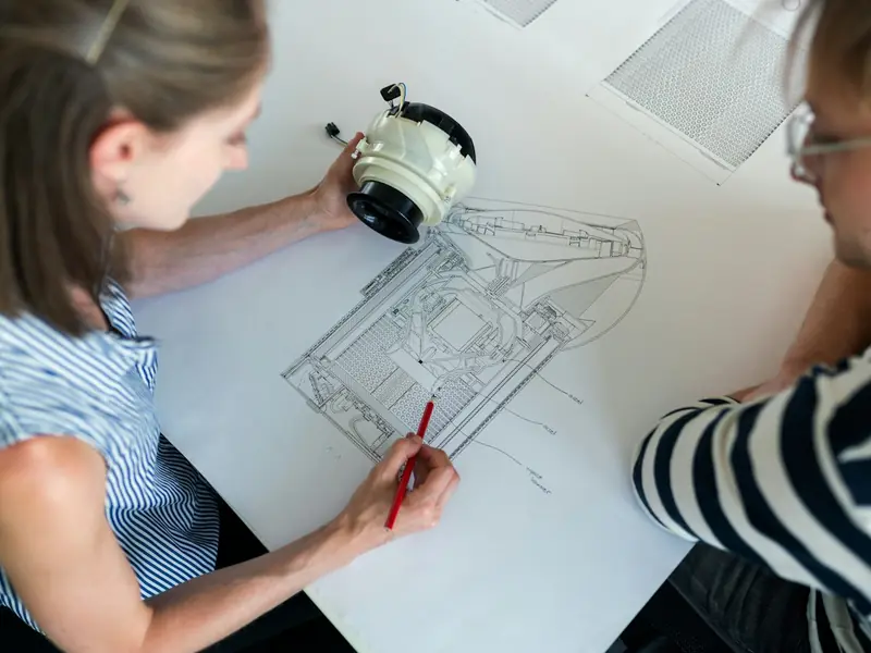 An engineer sketching a technical drawing at a desk